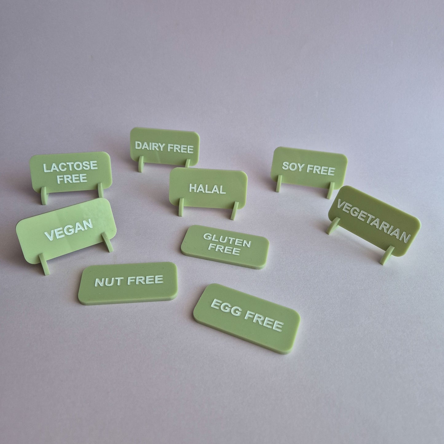 Set of green food allergy labels on a light gray background