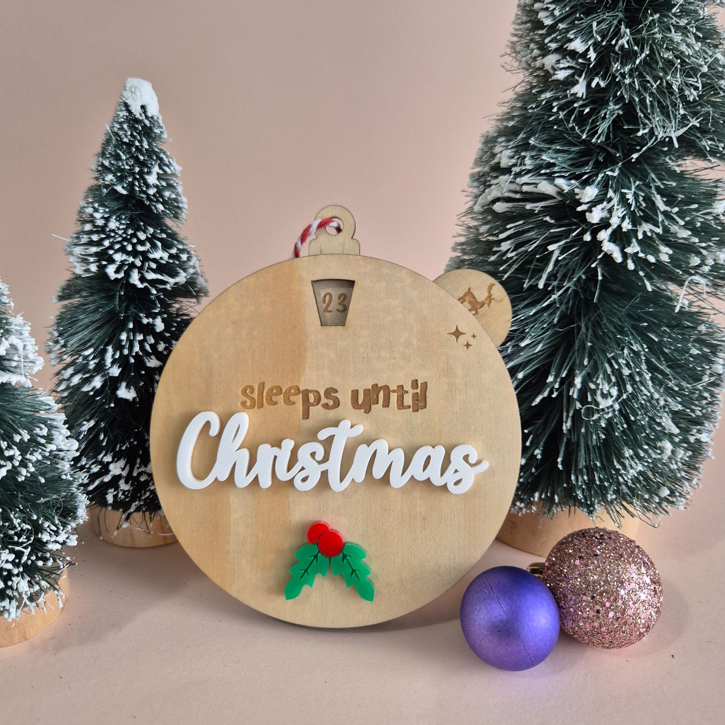 Wooden Christmas countdown ornament with decorative trees and ornaments on a neutral background