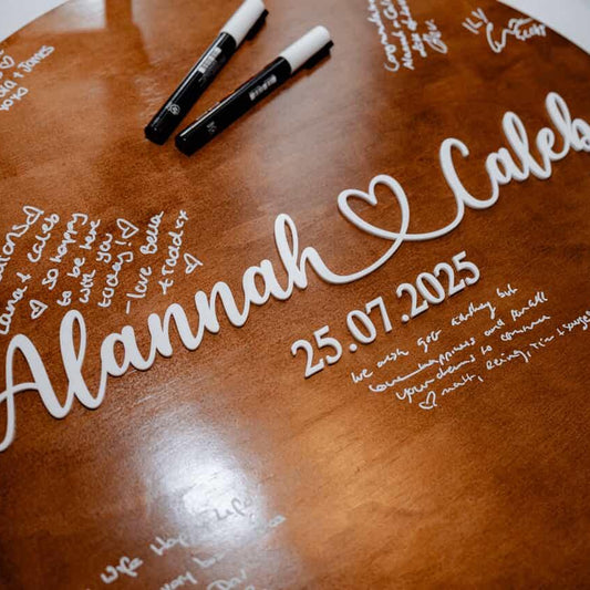 Finished timber circle with acrylic names and date for wedding that has been used as a guestbook